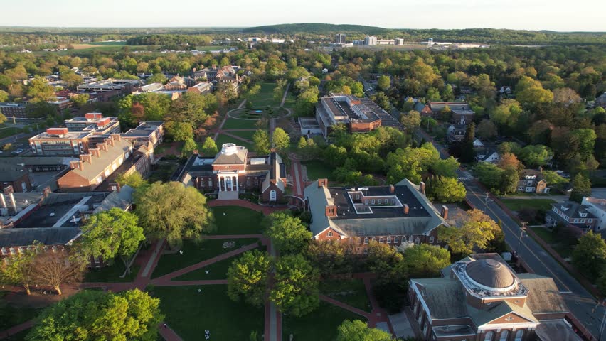 University of Delaware drone descent over green quad golden hour spring afternoon 