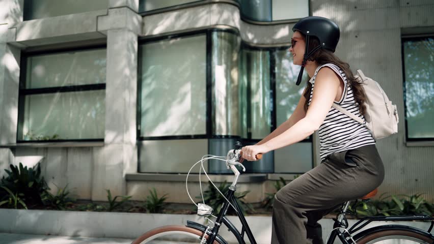 Video of confident cheerful woman riding electric push scooter through the city