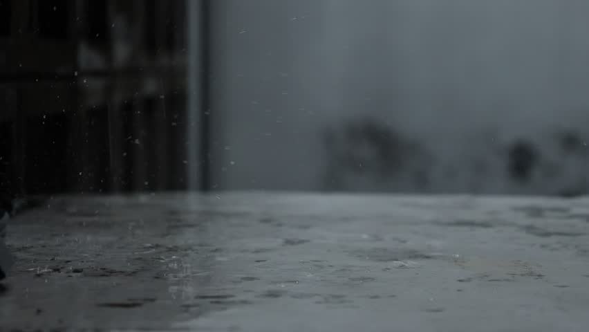 Raindrops falling down onto road floor texture. Heavy water tropical rain drops fall splashes hit the floor.  Royalty-Free Stock Footage #3491769853