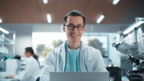 Portrait of an Asian Scientist Posing for Camera, Smiling. Young Male Biologist in a White Coat Working in a Modern Laboratory on a Laptop, Researching Medical Drug Products and Genome Editing - Powered by Shutterstock - Get 15% off with code: PIKWIZARD15