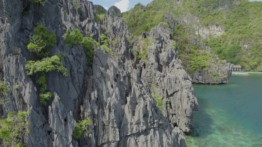 A beautiful view of a beach with a small island in the distance. The water is calm and the sky is clear. Aerial view of the amazing Big Lagoon in El Nido, Palawan, Philippines Royalty-Free Stock Footage #3491879309