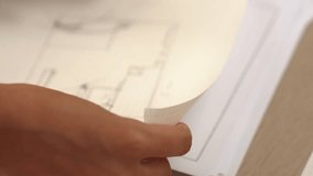 Video of clever architect or smart engineer using measurement and writing tool designing a detail on blueprint for construction accuracy at architectural office. Focus on hand. Closeup. Delineation.