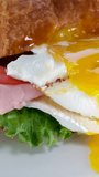 croissant with egg, meat, tomatoes and Brie cheese breakfast lunch on a plate served in a luxury hotel in France snack brunch enjoy food for a gourmet. next to orange juice
