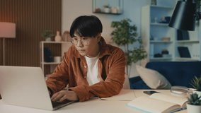 Young man Asian student studying on laptop and making notes, e-learning - Powered by Shutterstock - Get 15% off with code: PIKWIZARD15