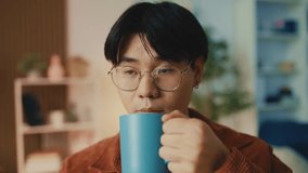 Funny Asian man drinks coffee and starts typing on laptop, inspired for work - Powered by Shutterstock - Get 15% off with code: PIKWIZARD15