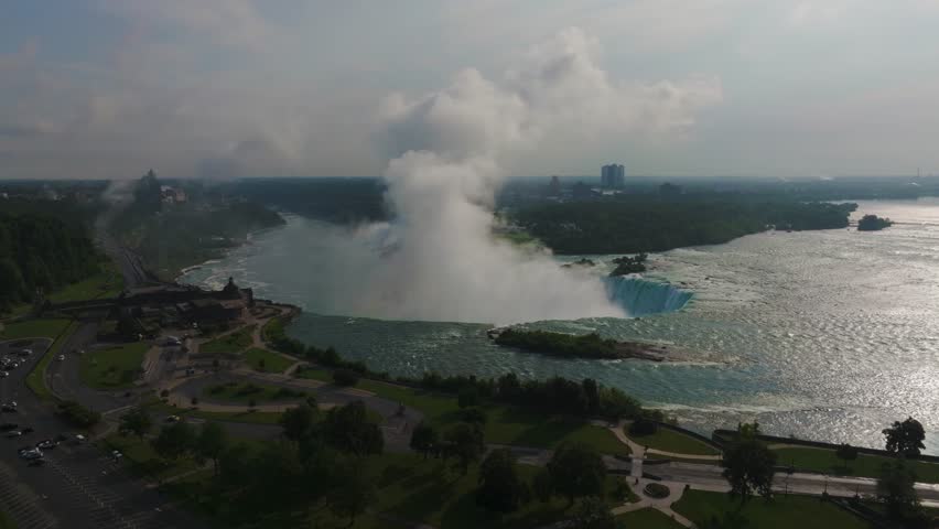 Niagara Falls on both the American and Canadian sides. Powerful waterfall of crystal clear waters. Majestic and misty rapids of the 56 km long Niagara River. Boat under the waterfalls with tourists.
