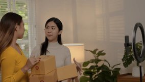 two beautiful entrepreneurs are going live to sell product online, two Asian business owners are talking to their customer about the product they sell, selling goods online