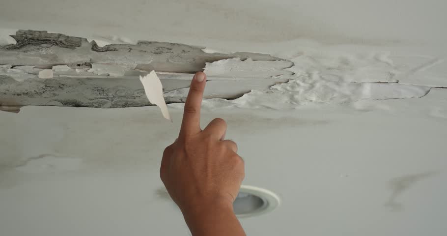 Male finger is peeling paint on ceiling, Office building or house problem for house service. High definition shot at 4K, 50 fps video footage.