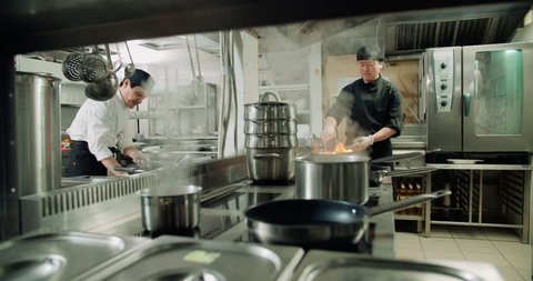 chef actively working in the kitchen of an Asian restaurant, 4K slow motion