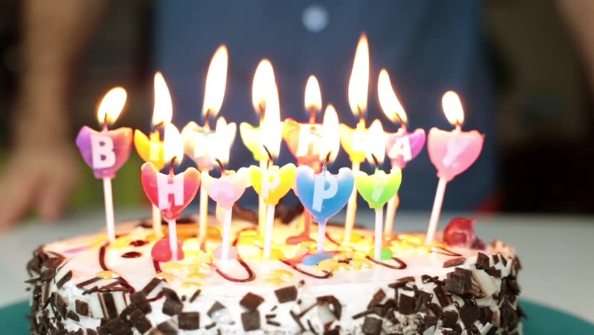 A man blows out candles on the cake. Birthday, holiday, cake with candles.