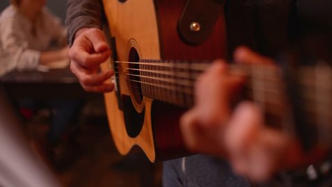 Close-up a Man Musician Hand play on a Guitar Strings in a Restaurant Evening
