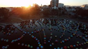 Aerial Panning Shot Of Multi Colored Balls In Famous City Park By Buildings Against Clear Sky - Los Angeles, California - Powered by Shutterstock - Get 15% off with code: PIKWIZARD15