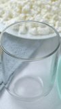 Pouring milk in glass from a bottle on a light background. Breakfast food and dessert. Healthy and Dairy product concept. Close up, vertical footage