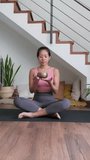 Slow motion vertical video of Asian woman playing tibetan singing bowl at home. Meditation practice concept.