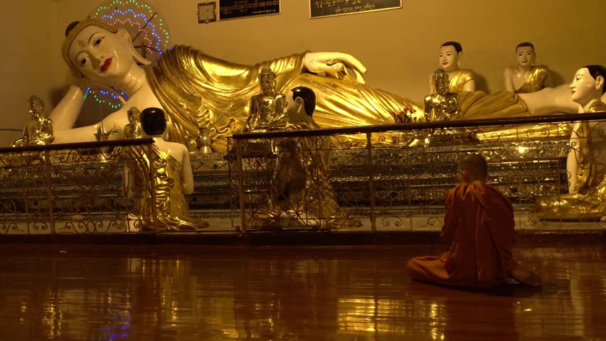 Burmese Unrecognizable Monk Praying in Buddhist Temple at Night