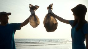 Two volunteer in volunteering charity activities cleaning up waste plastic on sand sea ocean beach. Couple Activist social responsibility and society activity for Environment . Ecology and CSR.
 - Powered by Shutterstock - Get 15% off with code: PIKWIZARD15