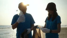 Two volunteer in volunteering charity activities cleaning up waste plastic on sand sea ocean beach. Couple Activist social responsibility and society activity for Environment . Ecology and CSR.
 - Powered by Shutterstock - Get 15% off with code: PIKWIZARD15