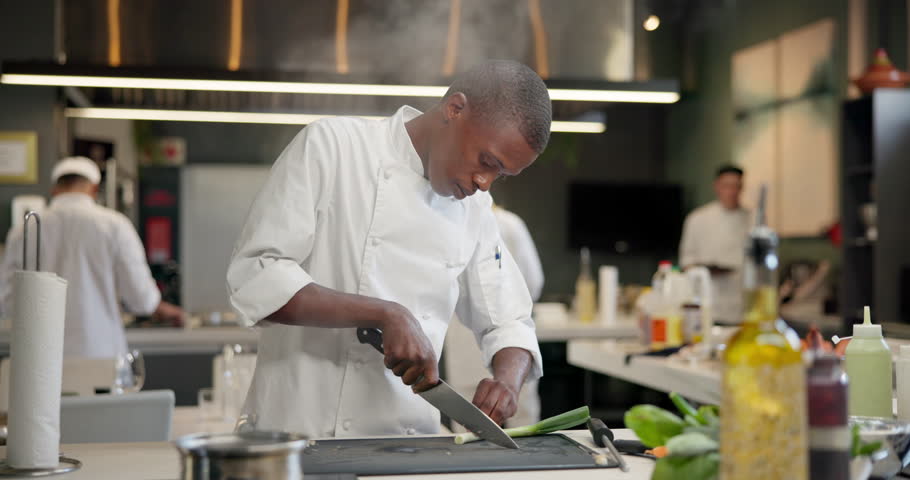 Man, chef and chopping vegetables in kitchen as professional cook, restaurant or meal prep. Male person, knife and culinary hospitality for fine dining dinner for healthy nutrition, food or cuisine