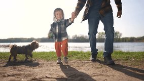 father and son baby toddler walking in the park. happy family kid dream concept. Baby Toddler walks in park with his father and parents near the water in summer the glare of the sun lifestyle - Powered by Shutterstock - Get 15% off with code: PIKWIZARD15