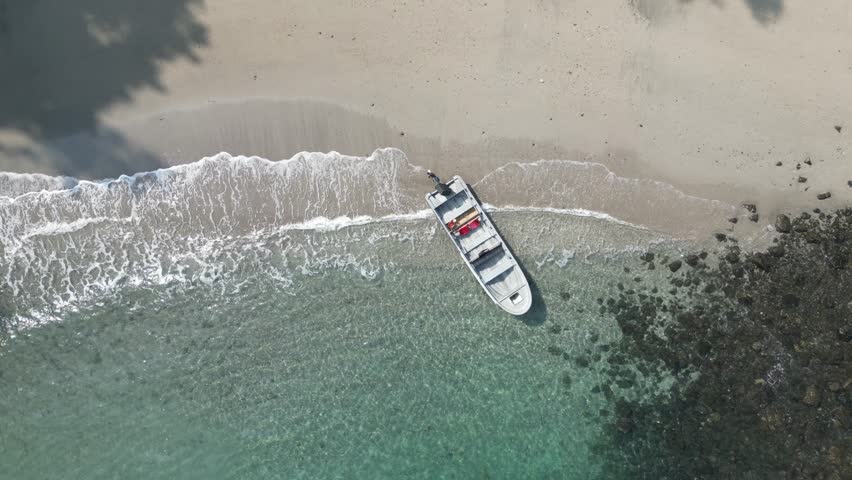 Small boat in turquoise water at a secluded beach in the Utría National Park between Bahía Solano and Nuquí in the Chocó department on the Pacific Coast of Colombia