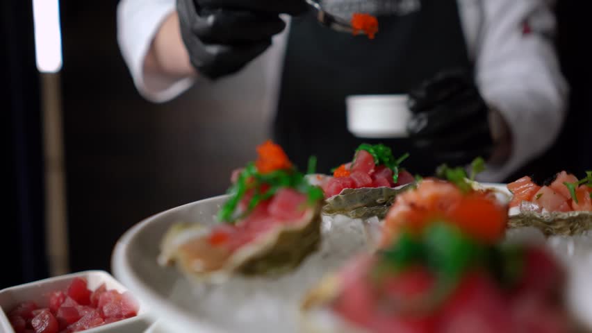Red salmon fish with caviar and spices rests on an oyster shell. Seafood dish in an expensive luxury restaurant. Japanese unusual gourmet food
