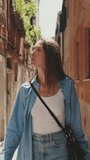 Vertical video, Young woman walking along narrow street of old city, Venice