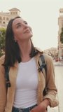 Vertical video, Close up, traveler girl, with backpack on her shoulders, walks in the historical part of European city