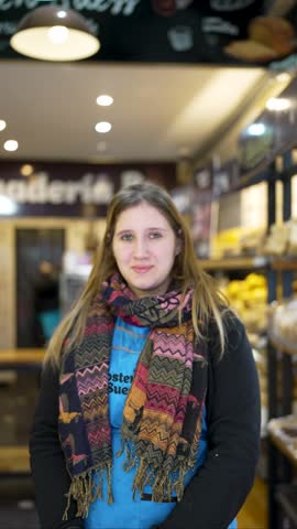 portrait of a bakery clerk woman inside a bakery in Argentina looking at camera