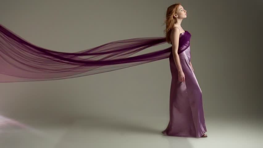 Fashion model in flying purple dress. Slow motion