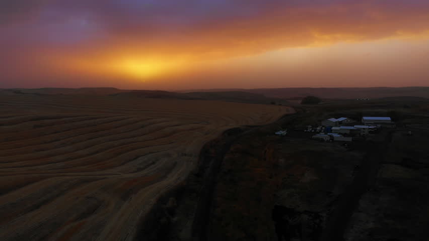 Aerial Panning Scenic View Of Structures On Hills Under Clouds In Sky At Sunset - Rural, Idaho