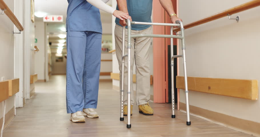 Walking frame, hospital and nurse with patient for help, support and care for medical service. Healthcare, clinic and legs of caregiver with man in corridor for wellness, rehabilitation and nursing Royalty-Free Stock Footage #3493103383