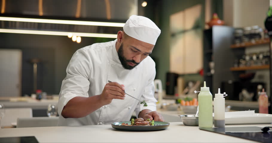 Chef, food and man plating in kitchen with garnish for gourmet meal at luxury hospitality diner. Service, catering and male culinary worker with dinner, lunch or supper at fine dining restaurant.