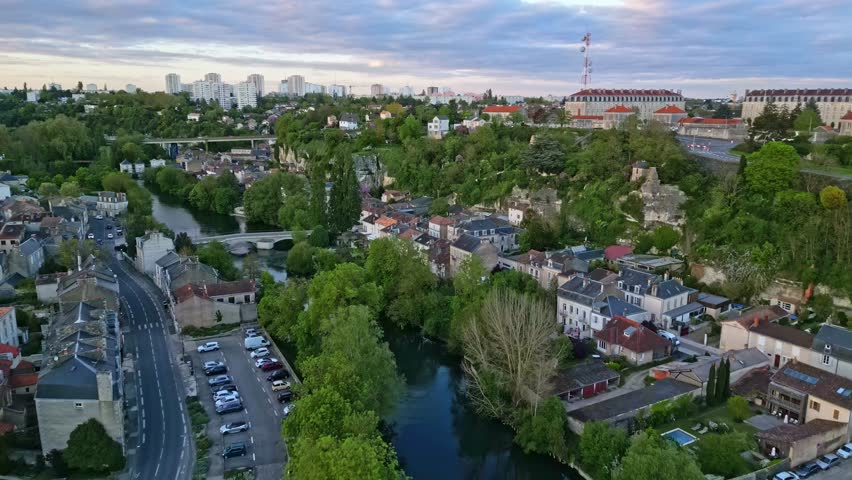 Clain river crossing Poitiers city, France. Aerial forward at sunset