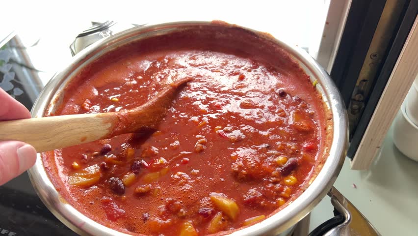 cooking delicious chili con carne in steel pot