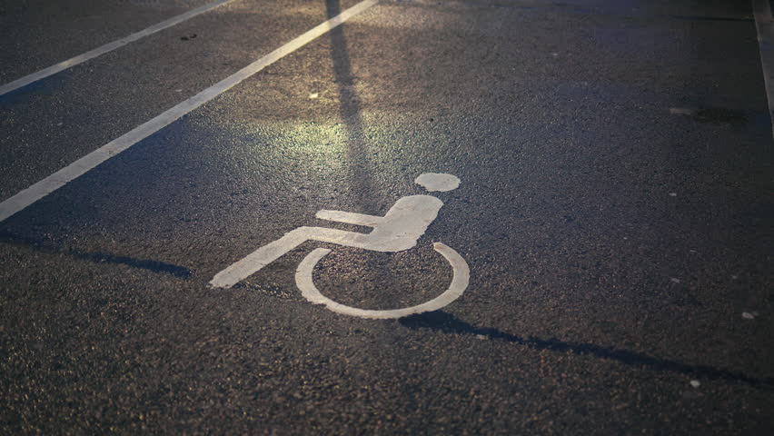 Parking for all: Handicapped or disabled sign displayed on the asphalt, designating an inclusive parking area
