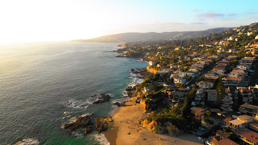 Aerial Forward Beautiful Shot Of Roofed Houses On Hills By Beach In Residential City During Sunny Day - Laguna Beach, California