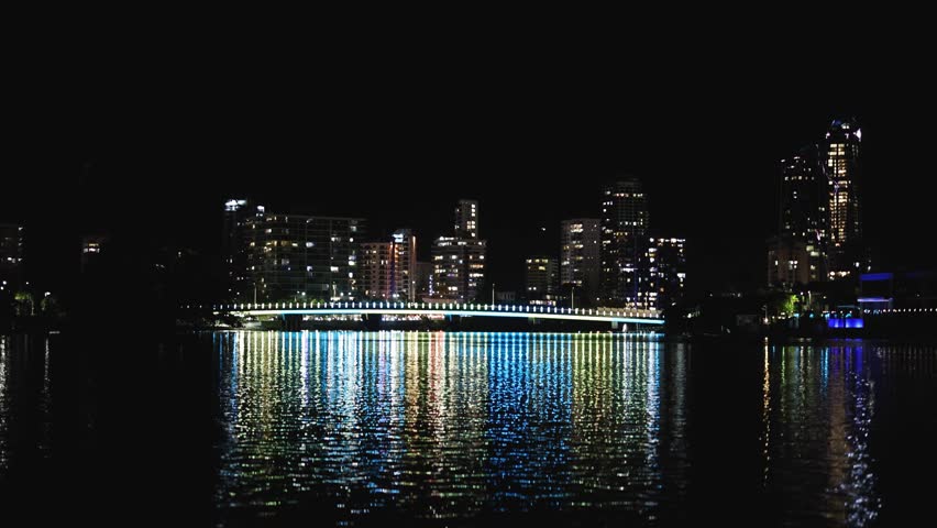 Timelapse of nighttime cityscape across water