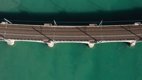 Train on the bridge over the river aerial view. Red high-speed train top view, slow motion on an arched bridge over a mountain river in Italy. Red train in Europe. Arched bridge over the water. - Powered by Shutterstock - Get 15% off with code: PIKWIZARD15