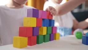children toddler group playing with blocks. development fine motor skills kindergarten concept sunset. children brother sister group playing cubes table near window. children playing with blocks - Powered by Shutterstock - Get 15% off with code: PIKWIZARD15