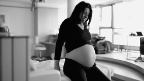 Dramatic scene of pregnant woman seated by bedside at hospital having contractions struggling with pain during pre labor, breathing deeply suffering during childbirth in monochrome - Powered by Shutterstock - Get 15% off with code: PIKWIZARD15