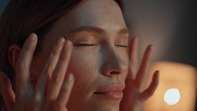Beautiful woman massaging face at evening routine in home close up. Portrait of smiling girl touching perfect skin by fingers with cosmetics. Happy lady making facial skincare procedure in bedtime. - Powered by Shutterstock - Get 15% off with code: PIKWIZARD15