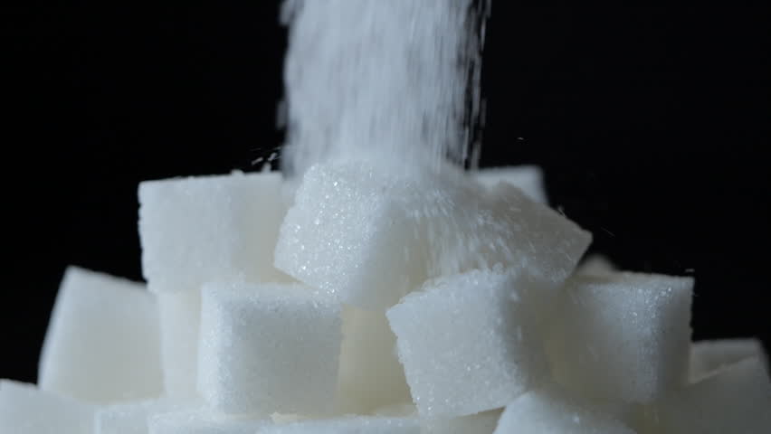 Pile of Unhealthy White Sugar Cubes on Black Background. Slow Motion of Pile of White Sugar Falling on Sugar Cubes. Texture Background. Concept of Unhealthy Eating, Diabetes, Obesity, Heart Disease.