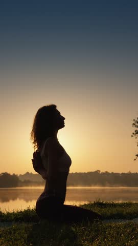 Young girl relaxing in nature, working on stretching and health, doing yoga, keeping body and mind in harmony with nature.