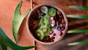 bowl healthy with kiwi, almond, banana and nuts in balinese bowl