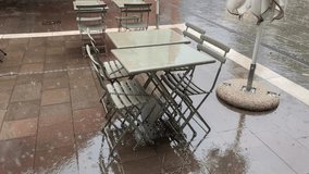 Horizontal video rain dripping on a table in a restaurant standing on the street. 