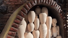 Assortment of lidded. terra cotta cookware in varying sizes. displayed on an old. wooden table at a market in the Georgian Republic. Video DCI 4k. High quality 4k footage