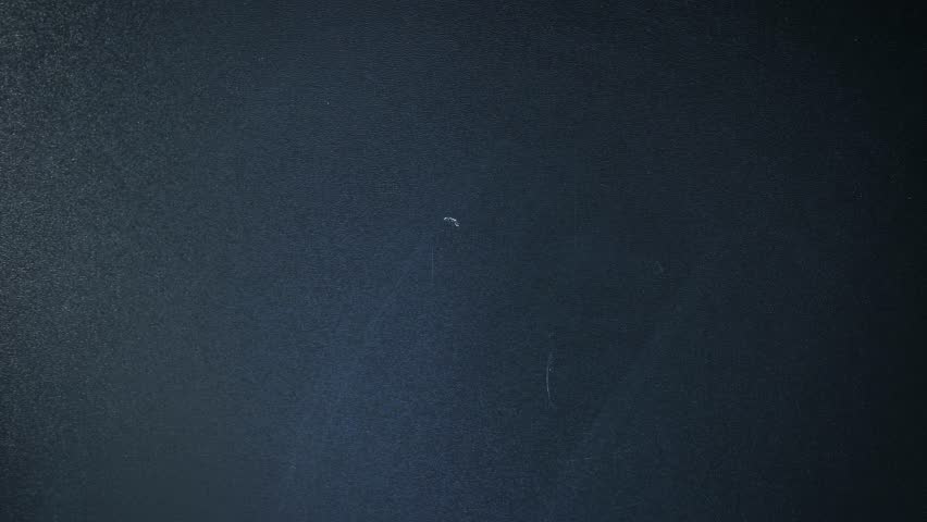 Male hand writes word HI on chalkboard. Drawing on chalkboard. Vertical video