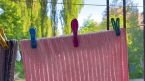 Bright Pink Fluffy Towel Blowing on Clothesline with Spring Green Bokeh Backdrop