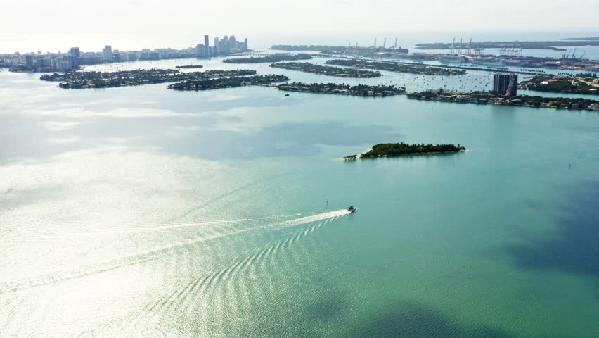 4k drone footage. View of the islands in the colorful green blue Biscayne Bay and the port of Miami on a sunny day. Transport water infrastructure of Florida. Holidays on yachts in Vice city