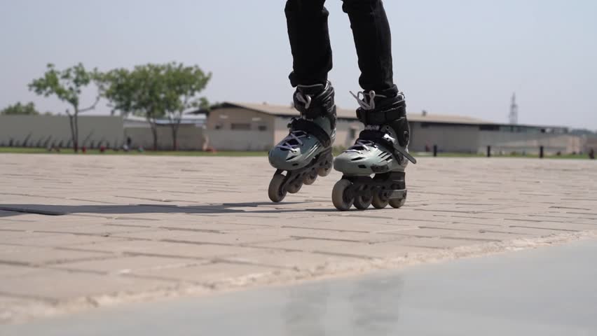Closeup of boys feet riding  roller skates outdoor. Unknown boy moving ans showing his skills on rollerblades outside - Roller Skating background Royalty-Free Stock Footage #3494248069